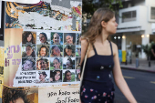 People make their way past images of those taken hostage or killed during the deadly October 7 attack, in Tel Aviv