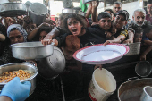 Palestinians gather to receive food cooked by a charity kitchen, amid the Israel-Hamas conflict, in the northern Gaza Strip