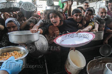 Palestinians gather to receive food cooked by a charity kitchen, amid the Israel-Hamas conflict, in the northern Gaza Strip