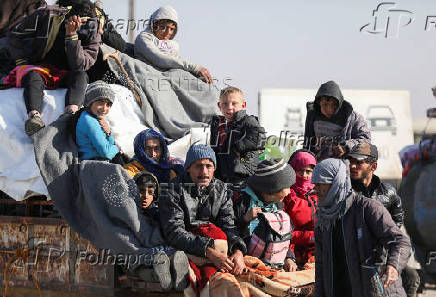 Displaced people who fled from Aleppo countryside, sit together on the back of a truck in Tabqa