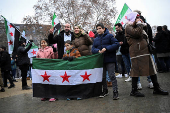 People gather on the streets, after Syrian rebels announced that they have ousted President Bashar al-Assad, in Berlin