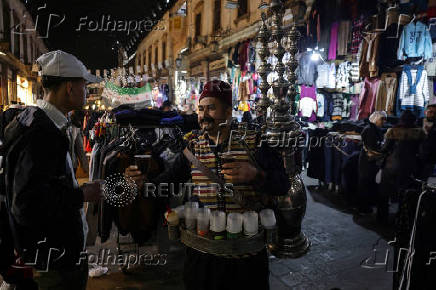 Abu Mohamed, a tamarind juice seller, poses for a photograph at the old city, in Damascus