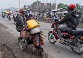 Internally displaced civilians from the camps in Munigi and Kibati, carry their belongings as they flee to Goma