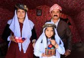 Iraqi Yazidis family poses for the camera, on the day of a ceremony for the occasion of Red Wednesday, the celebration of the Yazidi New Year, at Sharya camp on the outskirts of Duhok province