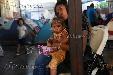 Migrants watch the first U.S. presidential debate at a shelter, in Tijuana