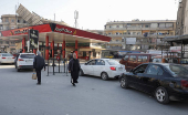 Cars stand in line as they wait to fuel up from a gas station in Aleppo