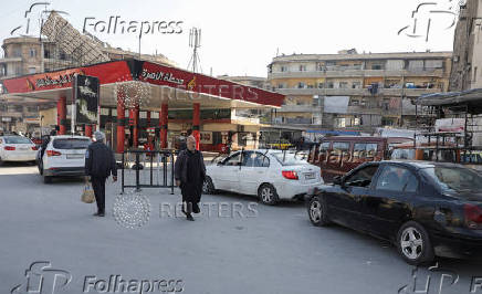 Cars stand in line as they wait to fuel up from a gas station in Aleppo