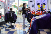 Ecuadorian immigrant Kenyi Arturo Melendez Sanchez, which had his asylum appointment canceled through the CBP One app and applied for asylum in Mexico, works in a barber shop in Tapachula