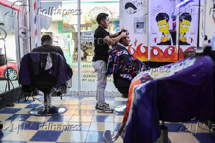 Ecuadorian immigrant Kenyi Arturo Melendez Sanchez, which had his asylum appointment canceled through the CBP One app and applied for asylum in Mexico, works in a barber shop in Tapachula