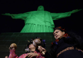 The statue of Christ the Redeemer is lit up in green to celebrate the Indigenous People Day in Rio de Janeiro