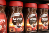 Nescaffe Classic are displayed on a shelf in a supermarket