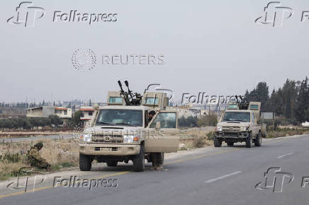 A rebel fighter sits near a vehicle in Homs countryside