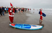 Surfing Santas take to the waves at the annual Christmas Eve event in Cocoa Beach