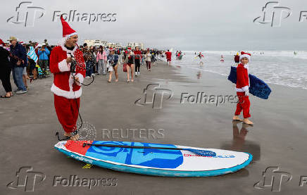 Surfing Santas take to the waves at the annual Christmas Eve event in Cocoa Beach