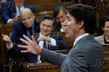 Canada's Prime Minister Justin Trudeau speaks while Conservative Party of Canada leader Pierre Poilievre pretends to play a violin in the background during Question Period in the House of Commons on Parliament Hill in Ottawa