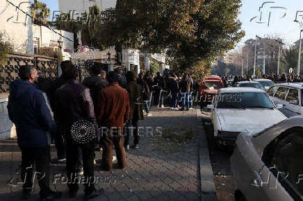 Former members of Syria's Bashar Al Assad's security forces wait to register for the identification and reconciliation process, in Damascus