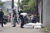 Policial carrega saco de explosivos
