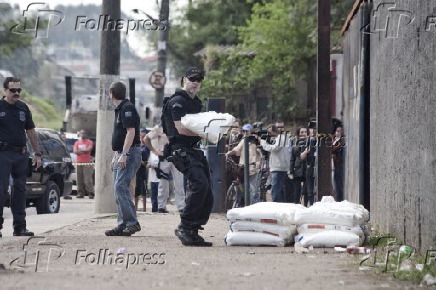 Policial carrega saco de explosivos