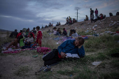 Migrant man reads Bible while searching for entry into the U.S. from Mexico