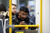 A man uses his smartphone on the tram in Manchester