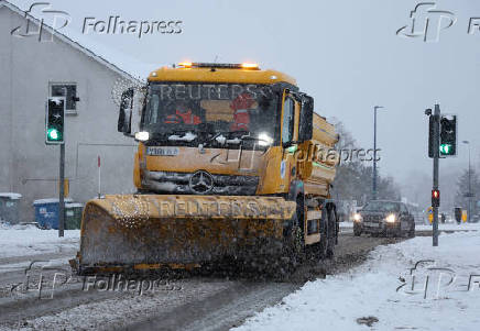 A snow plough operates in Aviemore, Scotland