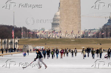 People skate on the ice-covered Lincoln Memorial Reflecting Pool on the National Mall, in Washington