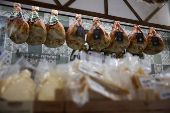 Dry-cured hams are hung at a grocery shop in Rome