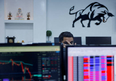 FILE PHOTO: A broker reacts as he trades at his computer terminal inside a stock brokerage firm in Mumbai