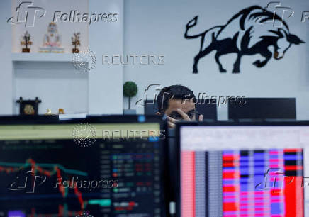 FILE PHOTO: A broker reacts as he trades at his computer terminal inside a stock brokerage firm in Mumbai