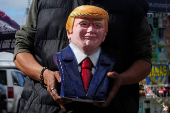 A vendor holds a bust of U.S. President Donald Trump at the San Ysidro border crossing in Tijuana