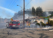 Firefighters work to stop a fire that damaged homes, in Oakland