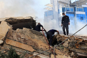 Civil defense members work at a damaged site, in the aftermath of Israeli strikes on Beirut suburbs