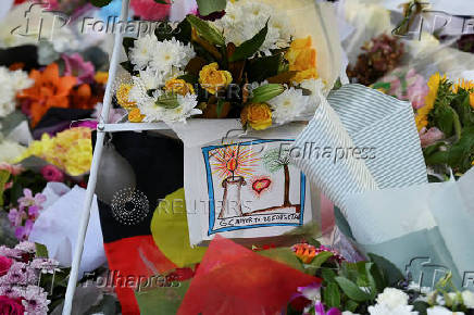 Floral tributes are left for victims of the attack at Westfield Bondi Junction shopping centre in Sydney on Saturday