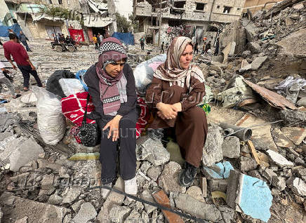Palestinians inspect the damages following an Israeli raid in Nuseirat, in the central Gaza Strip