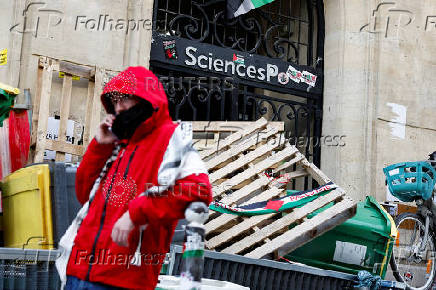 Masked youths take part in the occupation of a building of the Sciences Po University in support of Palestinians in Gaza, in Paris