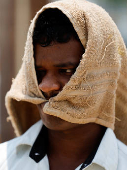 Man walks with a cloth covering his head on a hot day in Mumbai