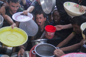 Palestinians gather to receive food cooked by a charity kitchen, amid the Israel-Hamas conflict, in the northern Gaza Strip