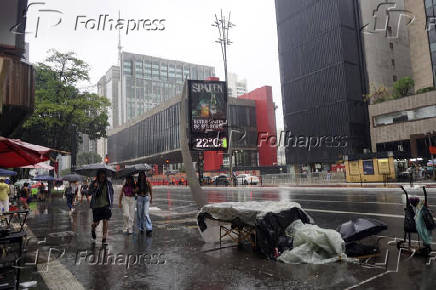 Pedestres enfrentam chuva na Avenida Paulsita, em So Paulo (SP)