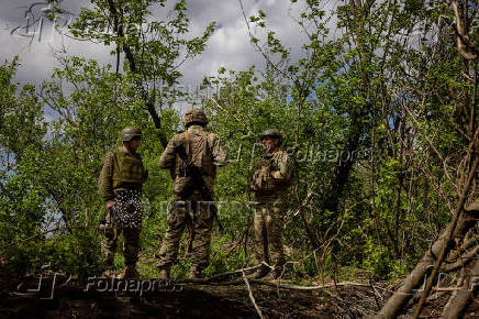 Ukrainian servicemen of the 22nd Separate Mechanised Brigade stand near an artillery position on the outskirts of Chasiv Yar