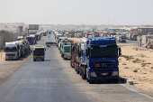 Trucks carrying aid line up near the Rafah border crossing between Egypt and the Gaza Strip, in Rafah