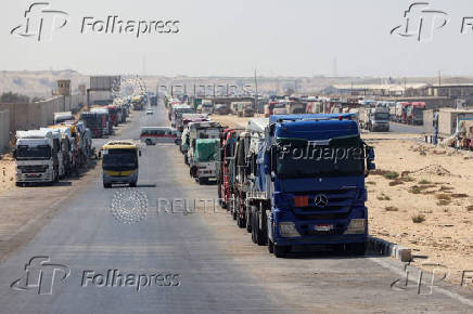 Trucks carrying aid line up near the Rafah border crossing between Egypt and the Gaza Strip, in Rafah