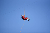 Guatemalan firefighter dressed as Santa Claus rappels down the Vacas Bridge to give toys to children, in Guatemala City