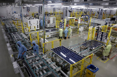 Workers assemble Photovoltaic Modules at the plant of Adani Green Energy Ltd (AGEL) in Mundra