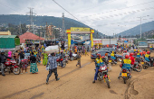 Motorists and motorcyclists move along a street in the outskirts Kigali