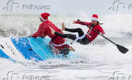 Surfing Santas take to the waves at the annual Christmas Eve event in Cocoa Beach