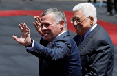 FILE PHOTO: Jordan's King Abdullah II and Palestinian President Mahmoud Abbas wave during a reception ceremony in the West Bank city of Ramallah