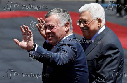 FILE PHOTO: Jordan's King Abdullah II and Palestinian President Mahmoud Abbas wave during a reception ceremony in the West Bank city of Ramallah