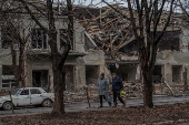 Residents walks past a building damaged by Russian military strikes in Pokrovsk