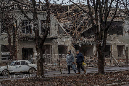 Residents walks past a building damaged by Russian military strikes in Pokrovsk