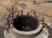A drone view of women drawing water from a well on a hot day in Kasara